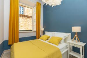 a blue bedroom with a yellow bed and a window at Kenova apartment Old Town in Dubrovnik