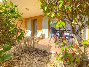 a patio with chairs and a table and trees at Appartement cosy pour un séjour bien-être in Saumane-de-Vaucluse