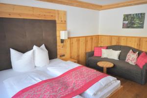 a bedroom with a bed and a couch at Hotel Central in Gerlos