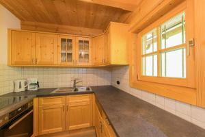 a kitchen with wooden cabinets and a window at Hainzbauer in Leogang