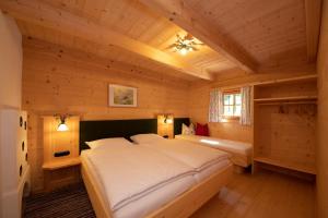 1 dormitorio con 1 cama en una cabaña de madera en Hainzbauer, en Leogang