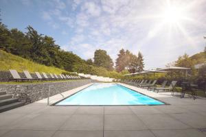 einen Pool mit Stühlen und Sonne in der Unterkunft Hotel Halfenstube & Villa Spa 1894 in Senheim
