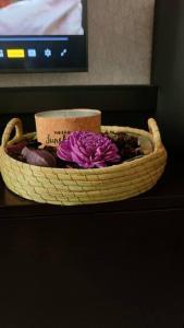 a basket with a purple flower on a table at Makazi Yetu in Dar es Salaam