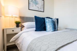 a bedroom with a bed with blue pillows at Stylish 2 bed apartment close to city in Bradford