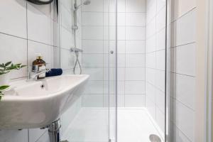 a white bathroom with a sink and a shower at Stylish 2 bed apartment close to city in Bradford