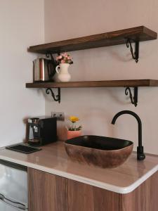 a bathroom with a wooden sink on a counter at Terracotta Boutique Beach Studios in Mythimna
