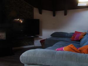 un soggiorno con divano e TV a schermo piatto di Àtic el Paller de Llau a Caregné