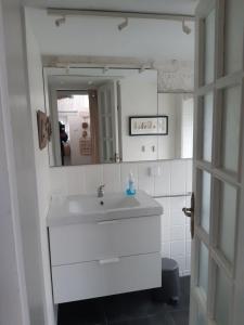 uma casa de banho branca com um lavatório e um espelho em Quinta da Atafona em Ribeirinha
