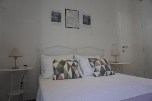 a bedroom with a white bed with two tables at Apartment Cosy & Sweet in Makarska