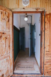 an open door in a room with wooden walls and floors at Weź tu Przystań - Mikołajek 1 in Pomiechówek