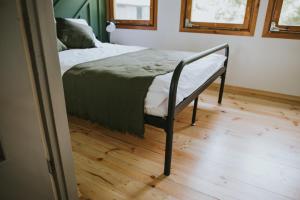 a bed in a room with a wooden floor at Weź tu Przystań - Mikołajek 1 in Pomiechówek