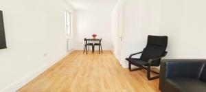 a living room with two chairs and a table at Phlox Garden in Sutton