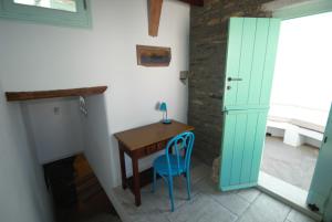 a small room with a table and a blue chair at Παραδοσιακό Σπίτι στον Πύργο in Panormos