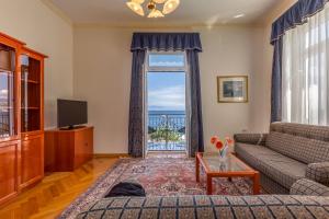 un soggiorno con divano e una grande finestra di Hotel Galeb a Opatija