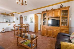 a living room with a couch and a tv and a table at Casa Laura in Frigiliana