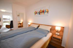 a bedroom with a large bed with blue sheets at Alte Uhrmacherei - Wohnen auf Zeit in Aurich