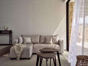 a living room with a couch and a table at The Sall Suites Complex A - Open Plan Suites with Private Pool in Agios Nikolaos +23 photos