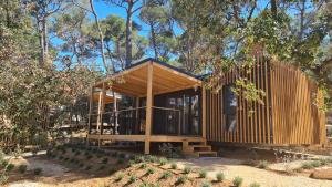 a house in the woods with a wooden facade at Pine Beach Pakostane Glamping Homes - All Inclusive light in Pakoštane