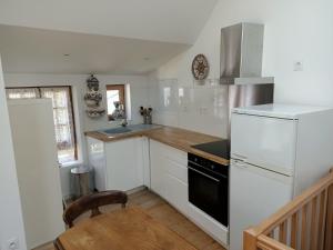Una cocina con electrodomésticos blancos y suelo de madera. en Petite maison proche de la mer, en La Baule