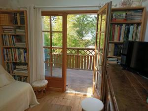 uma sala de estar com uma varanda com uma porta de vidro deslizante em Petite maison proche de la mer em La Baule