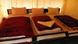 a bedroom with two beds with red comforters at Garjha Hill Sight Trekking & Camping in Sir Bhum Chun