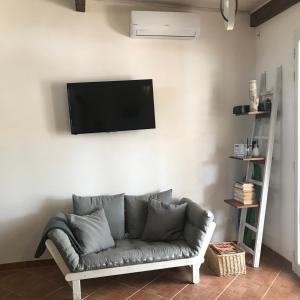 a living room with a couch and a television on a wall at CARPE DIEM Stagnone in Marsala