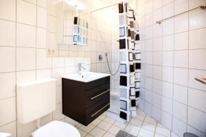 biała łazienka z umywalką i toaletą w obiekcie Modernes Studio in Stadtnähe w mieście Würzburg