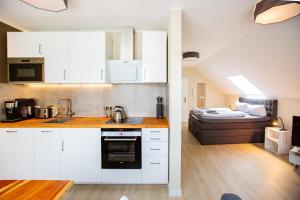 kuchnia z białymi szafkami oraz pokój z łóżkiem w obiekcie Modernes Studio in Stadtnähe w mieście Würzburg