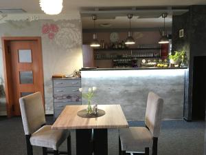 a kitchen with a table and chairs and a counter at Restaurace a Penzion U Lesa in Havířov