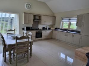 a kitchen with a table and a dining room at Finedays Cottage in Claudy
