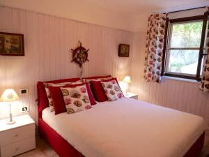 a bedroom with a large bed with red pillows at Appartamento in villa panoramica Maladroxia in Maladroscia