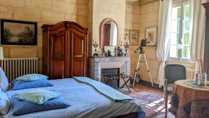 a bedroom with a bed and a fireplace at Domaine Mongiron in Nérigean