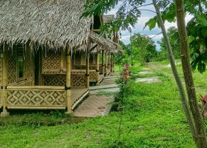 une maison avec un toit de chaume et un chemin dans l'établissement Lembah Cawene Hills Syariah RedPartner, à Gunungpicung