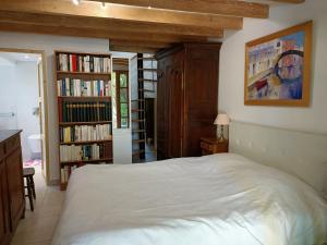 um quarto com uma cama e uma estante de livros com livros em Petite maison proche de la mer em La Baule