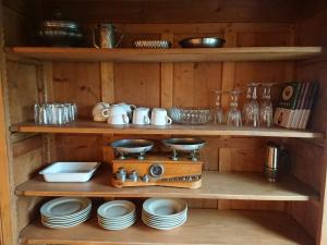 a wooden shelf with plates and dishes on it at Agriturismo Borgo Cà del Becca in Bioglio