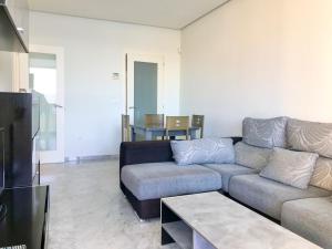 sala de estar con sofá y mesa en Gemelos 28 Blueline, en Benidorm