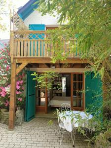 Casa con terraza con cama y mesa en Petite maison proche de la mer, en La Baule