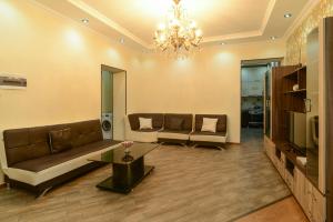 una sala de estar con 2 sofás y una lámpara de araña. en Old Tbilisi Apartment, en Tiflis