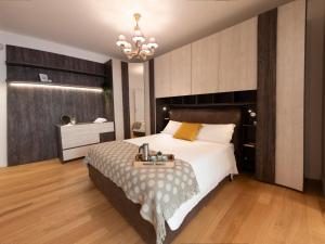 a bedroom with a large bed and a chandelier at The Best Rent - Modern apartment close to Sant'Agnese Metro Station in Rome