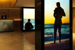 a woman standing in front of a television screen at QT Bondi in Sydney