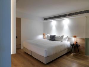 QT Bondi في سيدني: غرفة نوم بيضاء مع سرير كبير مع وسائد بيضاء