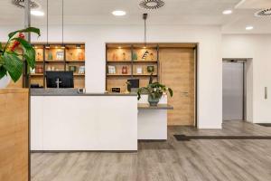 an office lobby with a white reception counter at Super 8 by Wyndham Chemnitz in Chemnitz