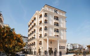 a tall white building with a clock on it at Radisson Collection Morina Hotel, Tirana in Tirana