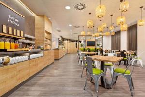 a restaurant with tables and chairs and a counter at Super 8 by Wyndham Chemnitz in Chemnitz