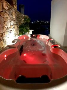 a red bath tub in a room with a stone wall at Blue View Villa #3 With Jakuzzi in Parasporos