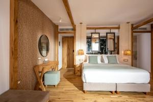 um quarto com uma grande cama branca e uma secretária em Stella Island Luxury Resort & Spa (Adults Only) em Hersonissos