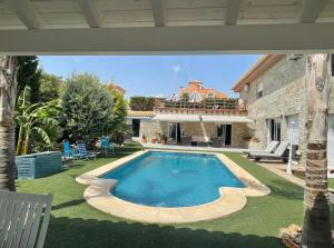 a swimming pool in the yard of a house at 1 Habitación con baño privado frente a la piscina, máximo para 4 personas, No es la casa completa,1cama y 1 sofa-cama in San Vicente del Raspeig