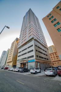 un edificio alto con coches estacionados en un estacionamiento en Platinum Coast Hotel Apartments, en Fujairah