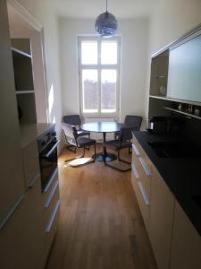 cocina con mesa, sillas y ventana en Casa Nostra - Moderne lichtdurchflutete Wohnung am Augarten, en Viena