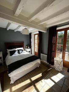 una camera da letto con un letto grande e alcune finestre di Charming Cottage in Chateau les Roches gardens a Mont-Saint-Jean
